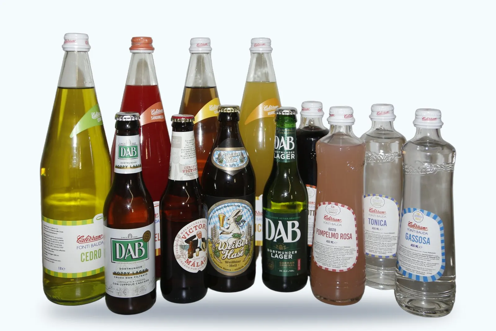 Aranciata, gassosa, tonica e cedro Calizzano in vetro insieme a bottiglie di birra